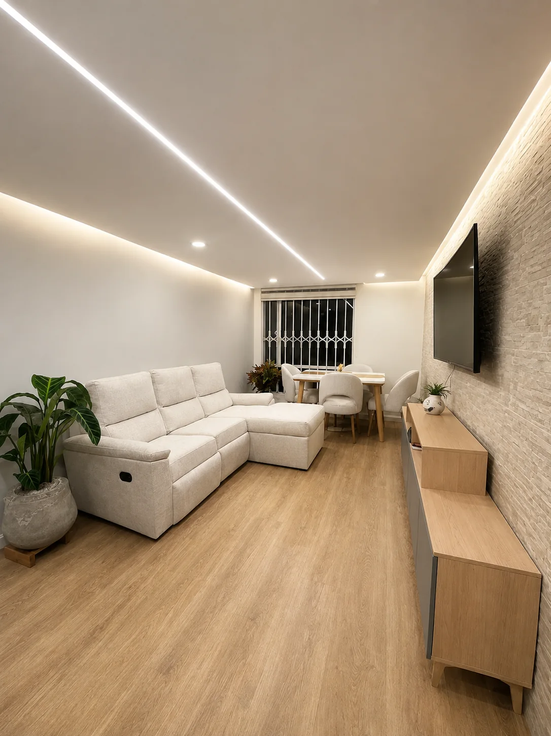 Sala y comedor remodelados por INNOVAPRO con iluminación LED y muro en piedra